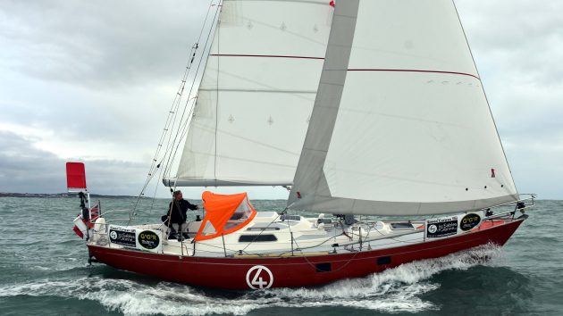 A Biscay 36 which white sails and a red hull being sailed offshore. The boat is being prepared for the rigours of the 2022 Golden Globe Race course