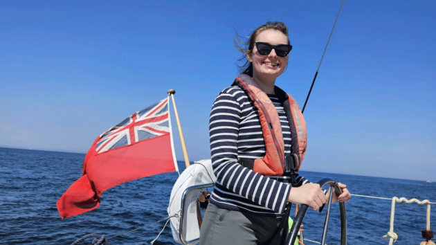 Jenny grinning at the helm