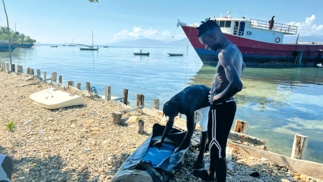 Local fishermen inspect the donated sail